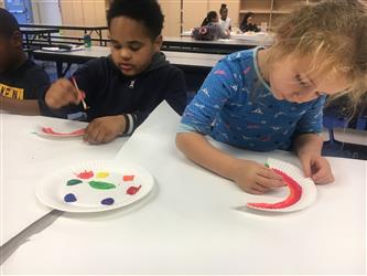 two students painting rainbows
